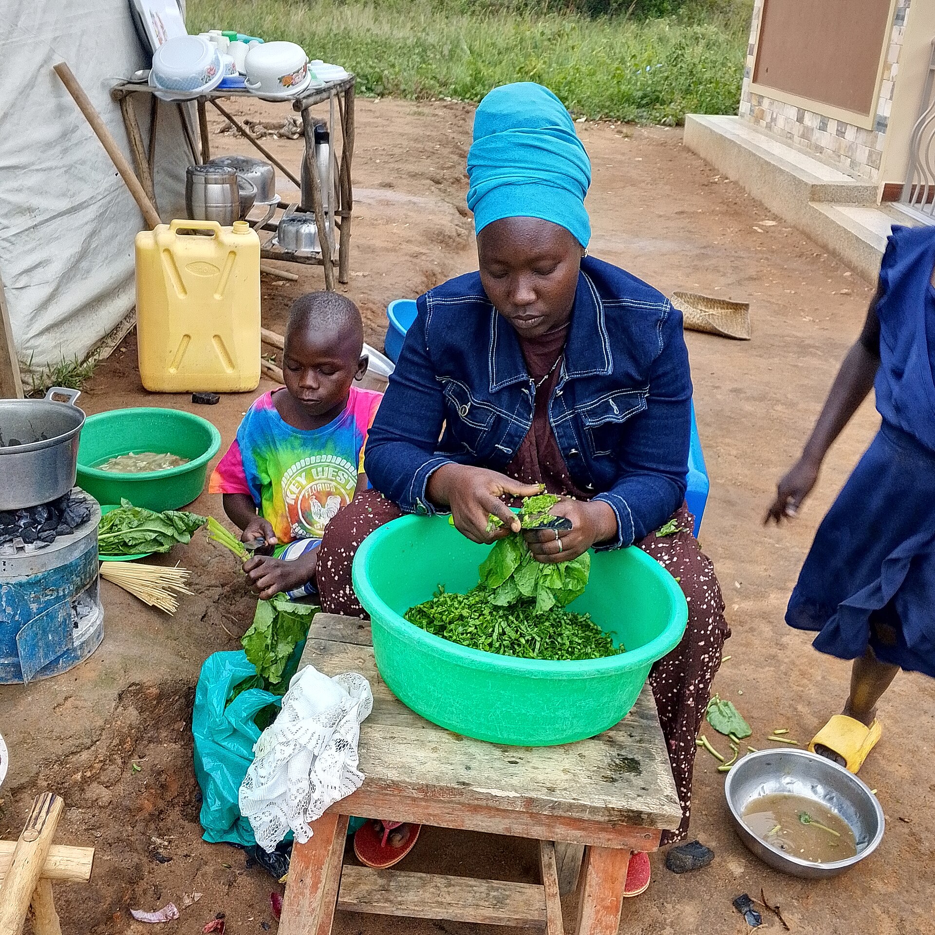 Real woman preparing leafy vegetables with people nearby